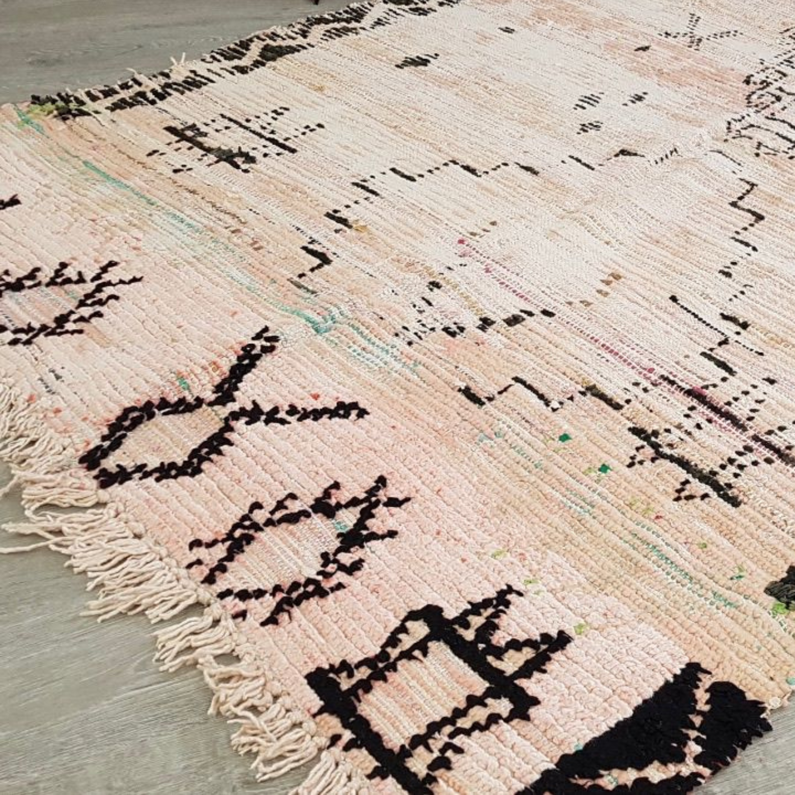 Textured rug with black patterns on a neutral background